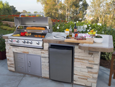 outdoor kitchen with grill and fridge